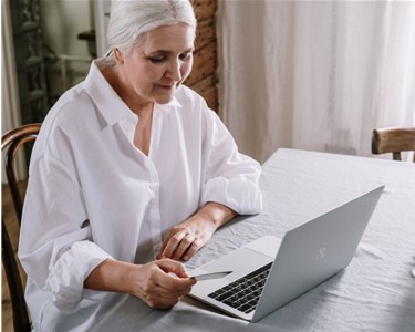 elderly woman sitting at computer