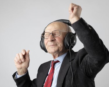 elderly man with headphones dancing